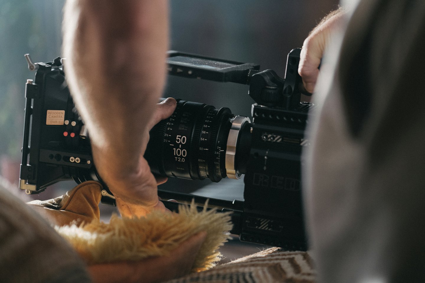 Mani che regolano l'obiettivo di una videocamera professionale.